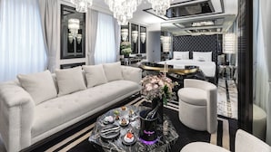 A luxurious living room with a plush sofa, a coffee table with a bottle of champagne, and a chandelier. - The Plein Hotel - Small Luxury Hotels of the World (Milan)