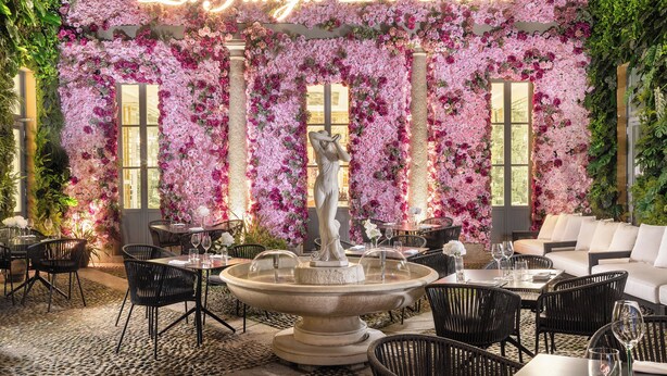 A restaurant with a floral wall, a fountain, and outdoor seating. - The Plein Hotel - Small Luxury Hotels of the World (Milan)