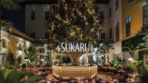 A tree with lights in front of a building labeled "The Sukaruni." - The Plein Hotel - Small Luxury Hotels of the World (Milan)