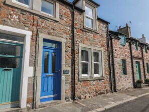 A row of stone houses with blue doors and white windows. - Haven Cottage (Kirkcudbright)