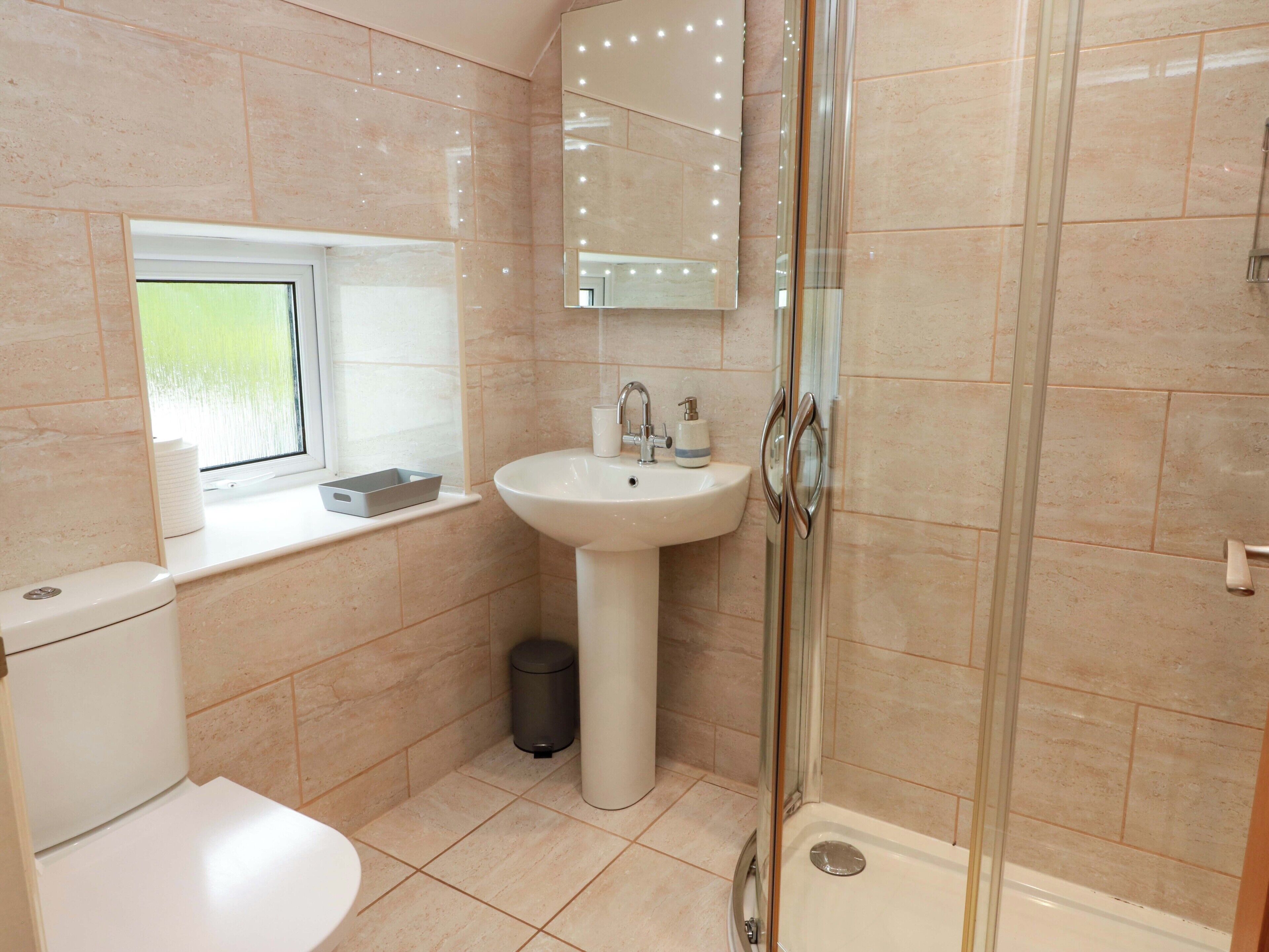 Een badkamer met toilet, wastafel en douche.