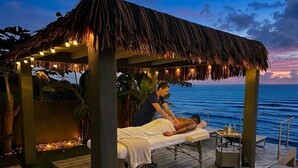A massage parlor with a thatched roof, wooden deck, and a view of the ocean. - Condostmaarten panoramic appartment (Adults Only) (Sint Maarten)