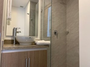 Standaard appartement | Badkamer | Een douche, handdoeken, zeep, toiletpapier