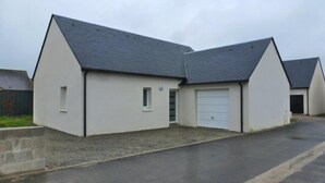 Un bâtiment à deux étages avec un garage et une petite fenêtre.