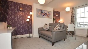 A modern living room with a grey sofa, a white desk, and a large window with curtains. - Home from home in style & comfort (Chester)