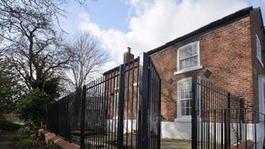 A brick house with a black metal gate and a small staircase leading to the front door. - Home from home in style & comfort (Chester)