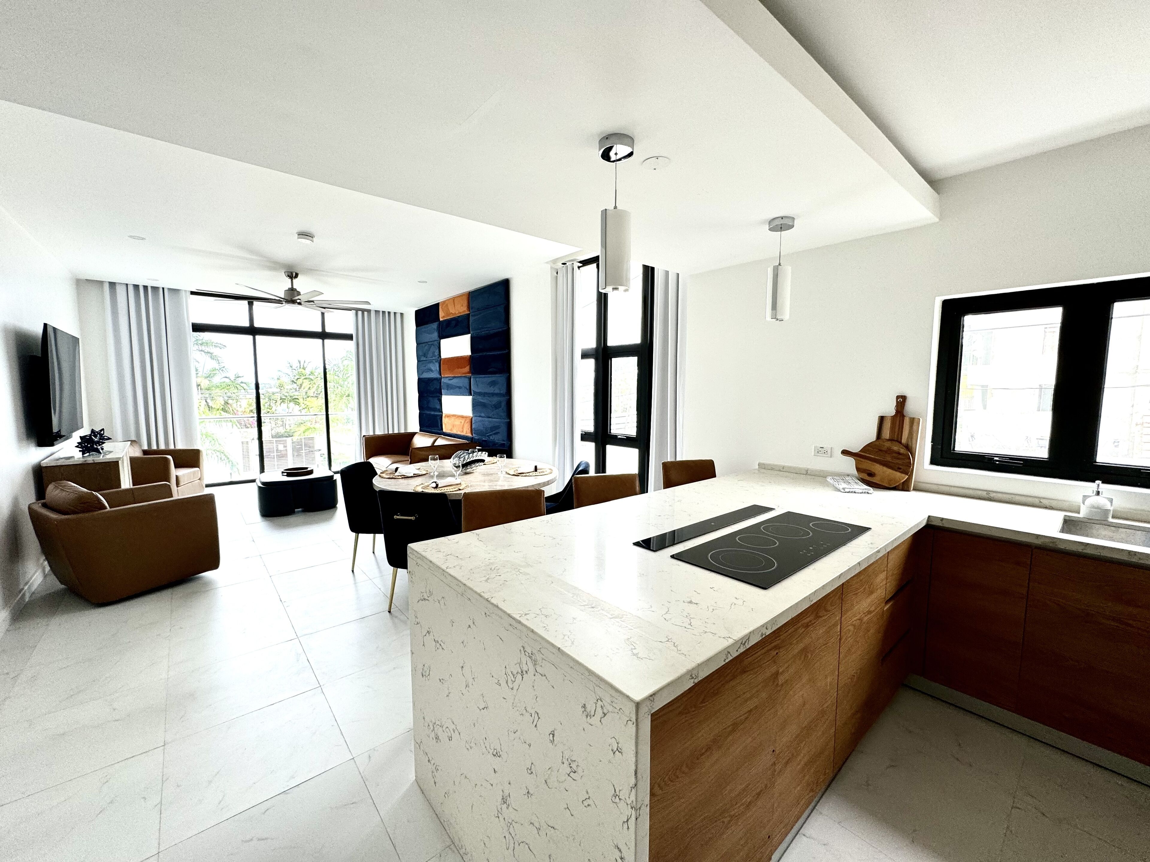 A modern living space with a kitchen, dining area, and seating area.