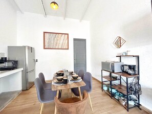 Enjoy meals in this kitchen and dining area, featuring a refrigerator, microwave, coffee maker, and dining table with chairs.