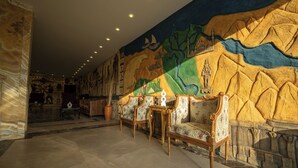 A lobby with ornate furniture, a large mural, and a stone wall. - King Pyramids View Hotel (Giza)