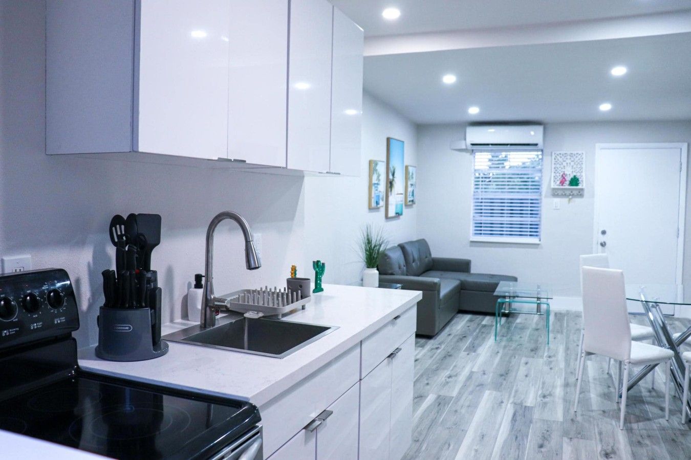 A modern kitchen with a built-in stove, a sink with a faucet, and a countertop with a knife block.