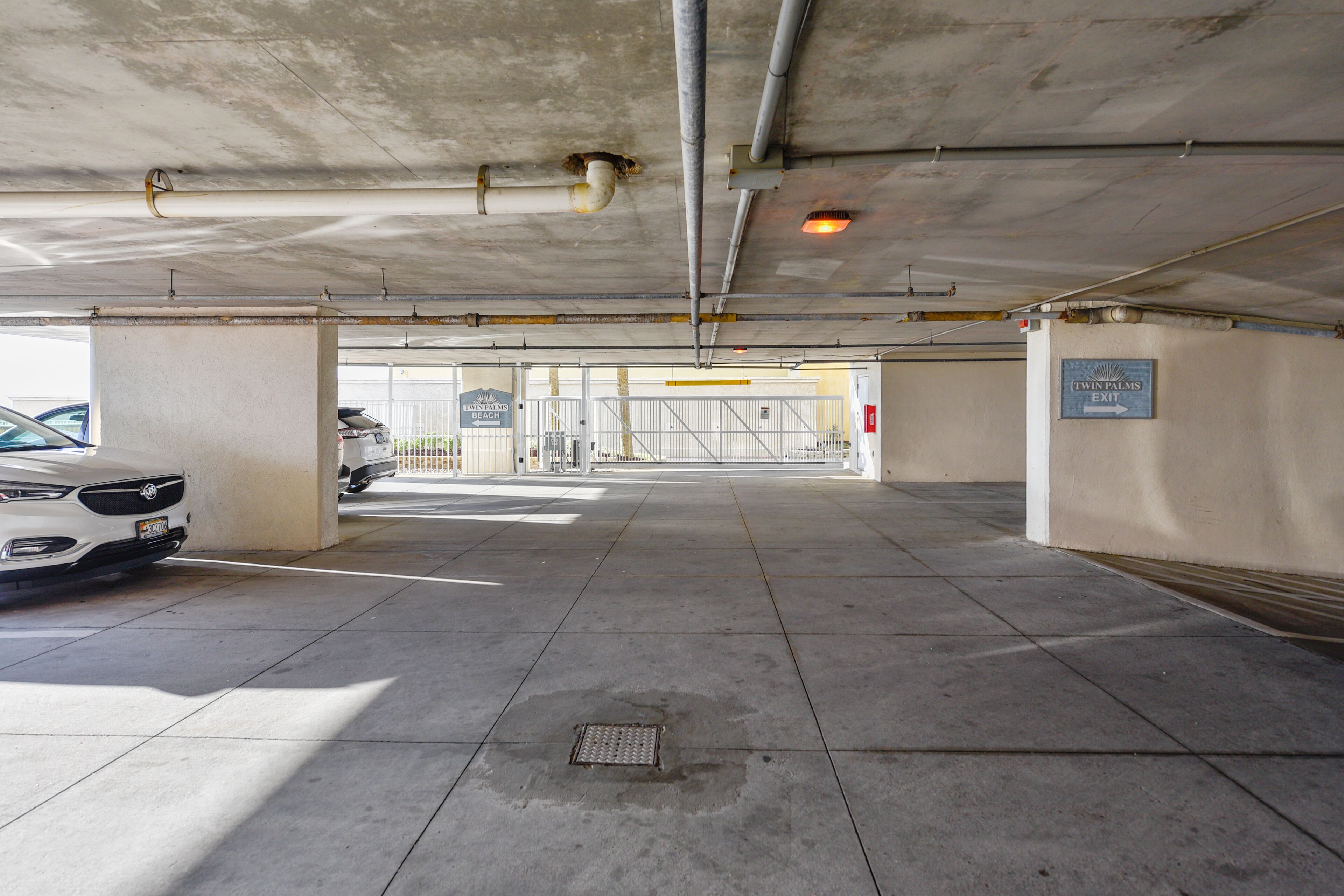 An underground parking garage with a white car parked on the left.