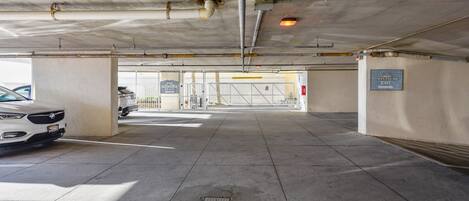 An underground parking garage with a white car parked on the left.