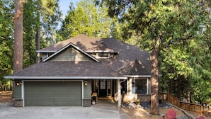 A two-story house with a garage, a covered porch, and a small deck.