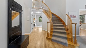 A staircase with wooden railings and carpeted steps leading to an upper floor.
