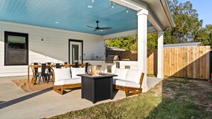 A covered patio with a fire pit, outdoor seating, and a ceiling fan. - Outdoor Kitchen - Walk to Beach - Fire Pit - Dogs (Gulfport)