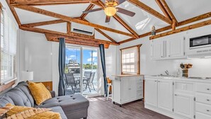 A modern kitchen with white cabinets and a built-in microwave. - Cabins at Bonefish Bay (Marathon)