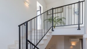 Un escalier avec des rampes noires menant à l’étage supérieur.