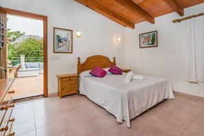 A bedroom with a wooden bed, two nightstands, a white bedspread, and two wall-mounted lights. - Cuixac, A Quiet Country Villa IN Pollensa (Pollença)