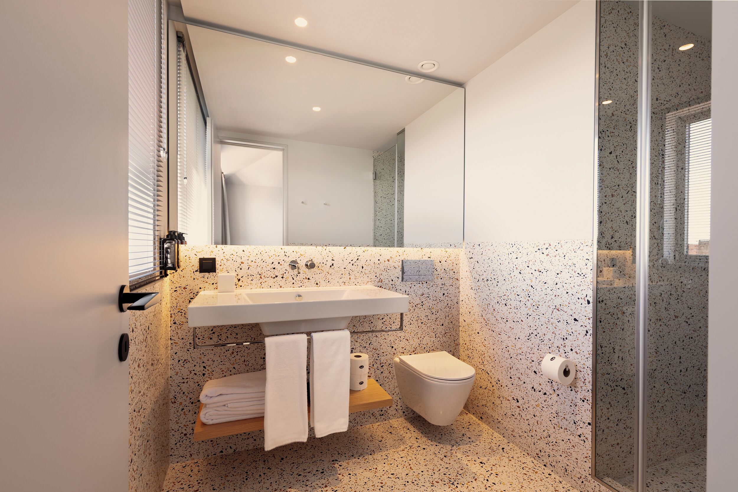 Ein modernes Badezimmer mit freistehender Waschanzeige, Toilette und Duschkabine aus Glas.