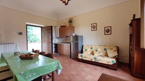 Una cocina compacta con una mesa de comedor, un sofá y un refrigerador.