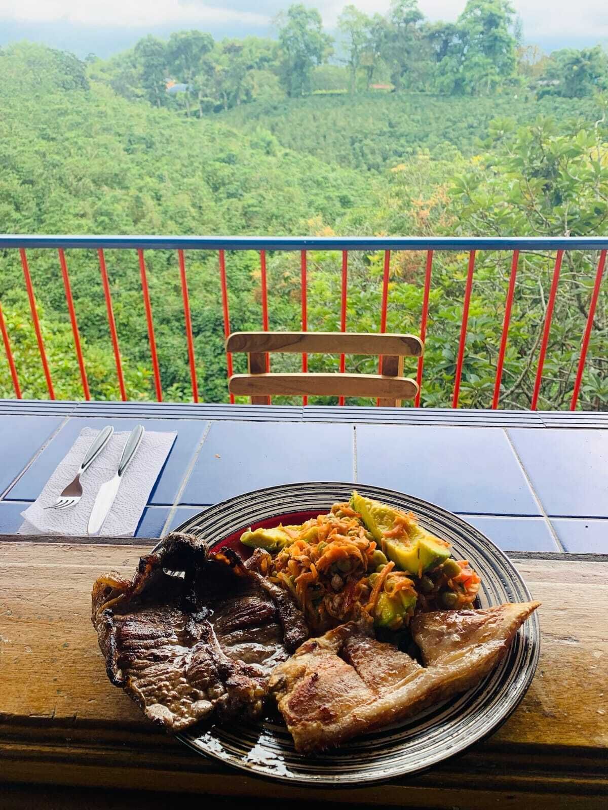 A dining table with a plate of food and a bench in the background.