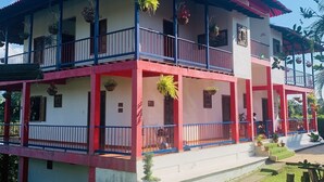 A two-story building with balconies, railings, and potted plants. - CALLE JARDIN FINCA HOTEL  (Armenia)