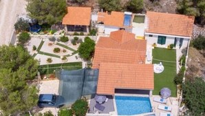 An aerial view of a residential property with a swimming pool, a covered patio, and a fenced garden area. - Seclude charmy house with pool 200m from sea (Duboka)