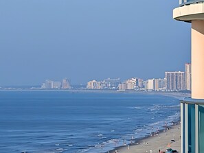 A coastal cityscape with a beach and high-rise buildings.