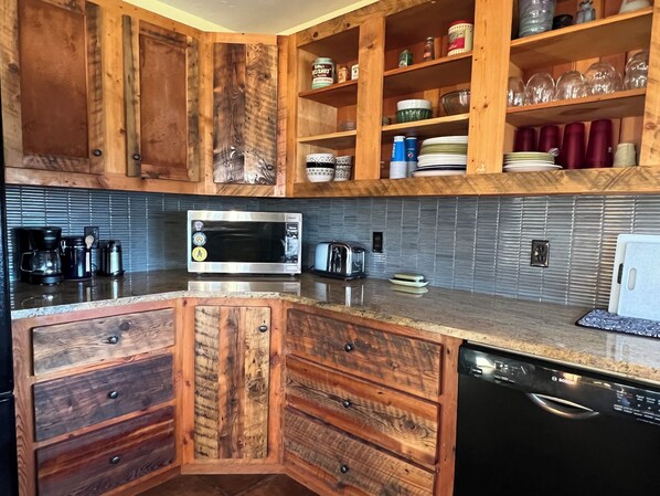 A kitchen with wooden cabinets, a microwave, a Bosch dishwasher, and a tiled backsplash. - Ski, Hike, bike, fish, hunt & Yellowstone. 4 bed, 3 bath with hot tub! Sleeps 8 (Clyde Park)