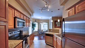A modern kitchen with wooden cabinets, stainless steel appliances, and a central island. - Amazing Casita with Upgrades Galore! (Scottsdale)