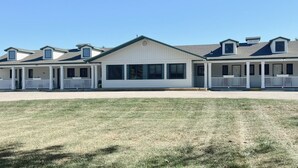 A row of single-story houses with attached porches and a central building with large windows. - Hampton Motel (Hampton)