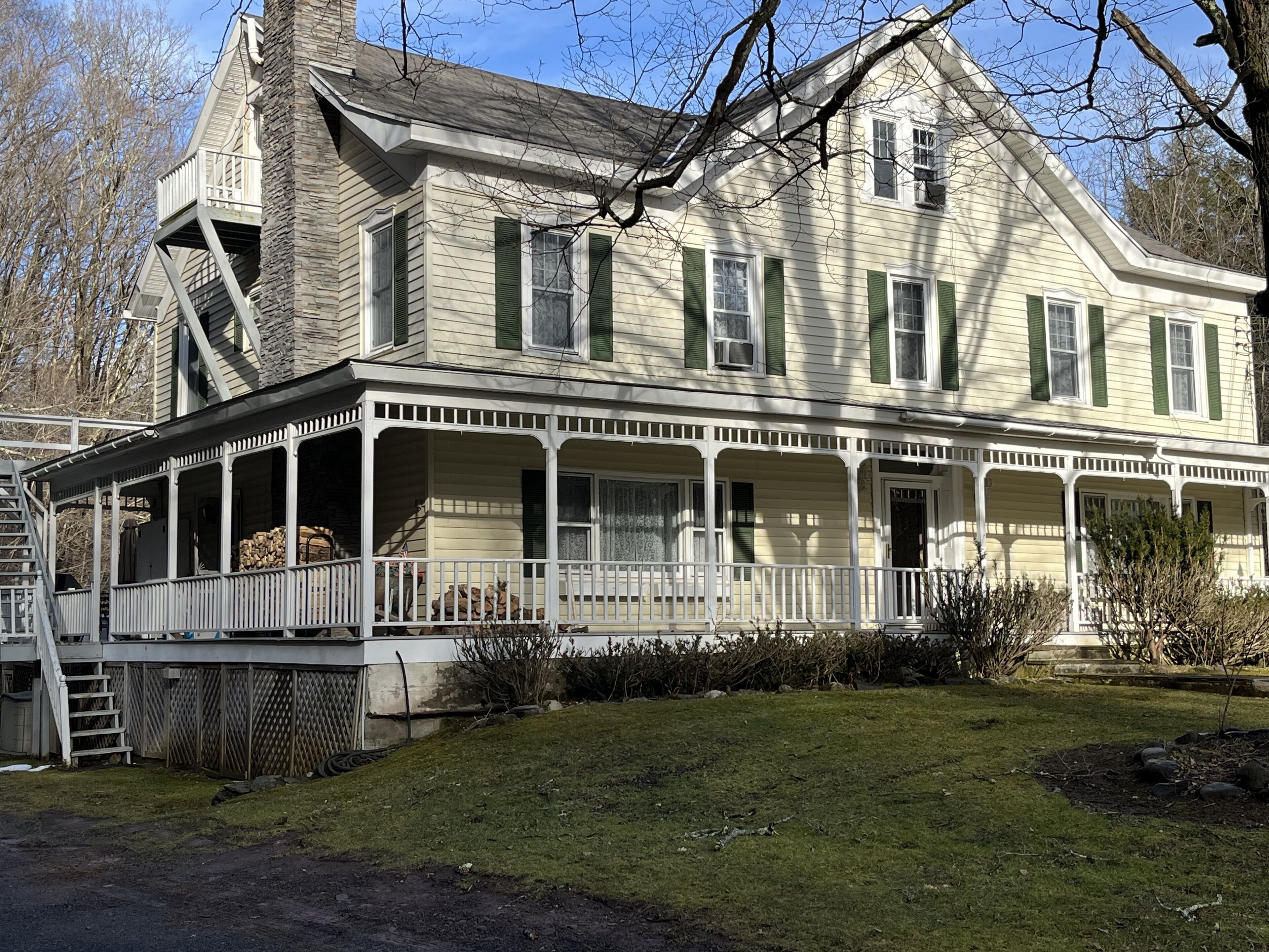 A large, two-story house with a porch and a covered front porch area.