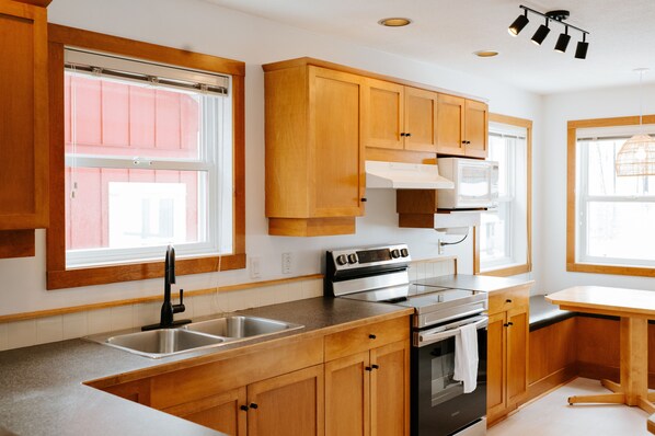 A kitchen with wooden cabinets, a stainless steel sink, and a built-in oven.