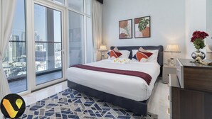 Una habitación de hotel moderna con una cama grande, vista a la ciudad y detalles decorativos.