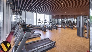 Un gimnasio moderno con cintas de correr, elípticas y equipo de pesas.