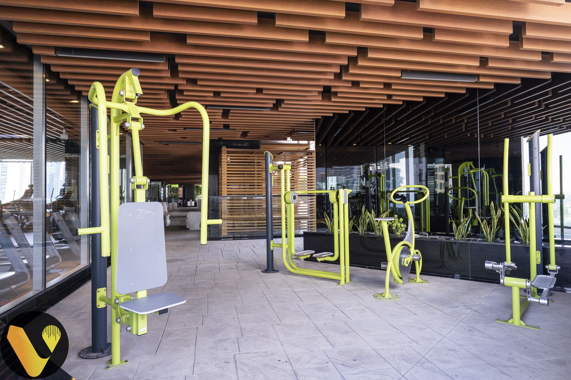 Un gimnasio al aire libre con diversos equipos de ejercicio, como un banco, barras de dominadas y una bicicleta estática.