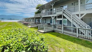 A multi-story motel with balconies and a view of a lake. - Waters Edge Lodge (Diamond Point)