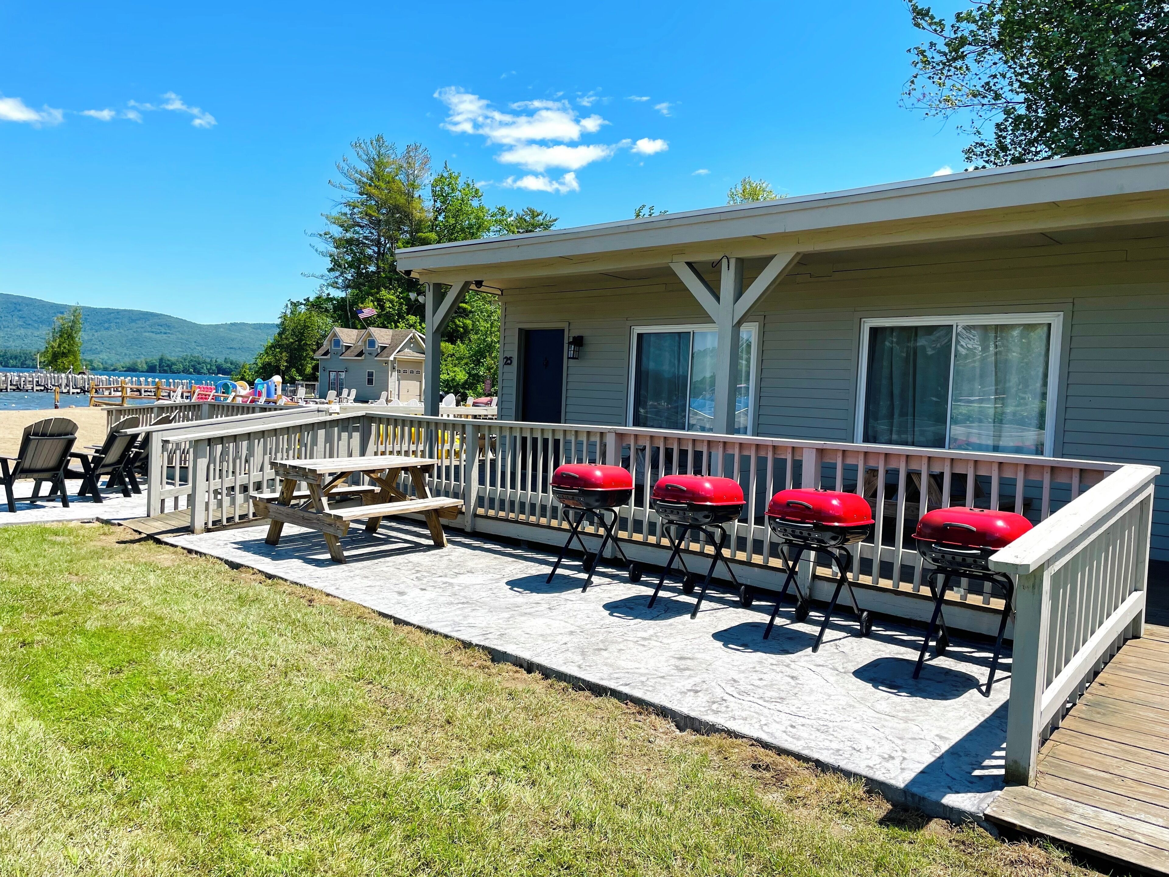 A covered deck with outdoor seating and a view of the lake.
