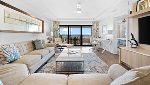Un salon moderne avec un canapé, une table basse et une vue sur l’océan.
