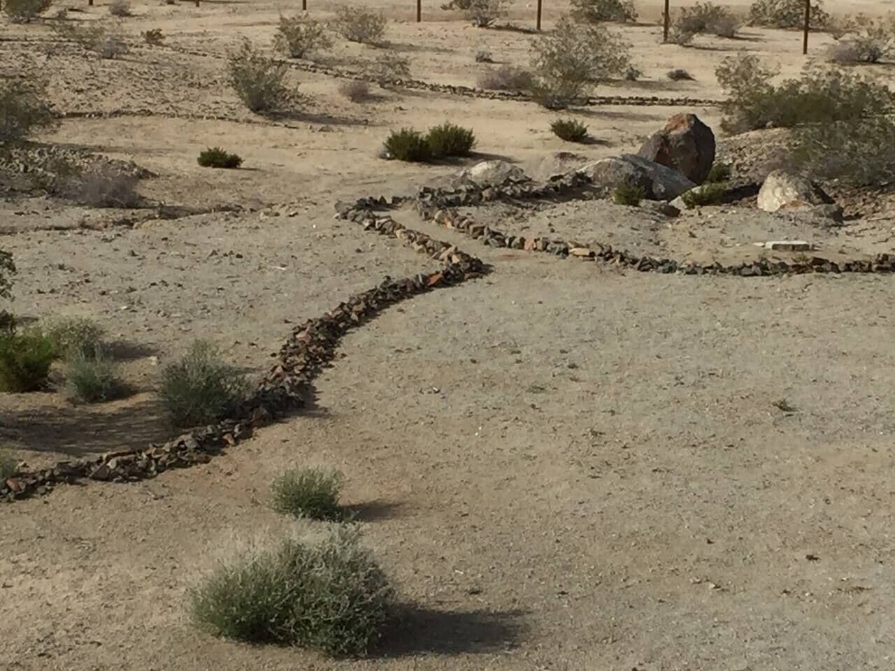A dry, rocky landscape with sparse vegetation and a winding path.