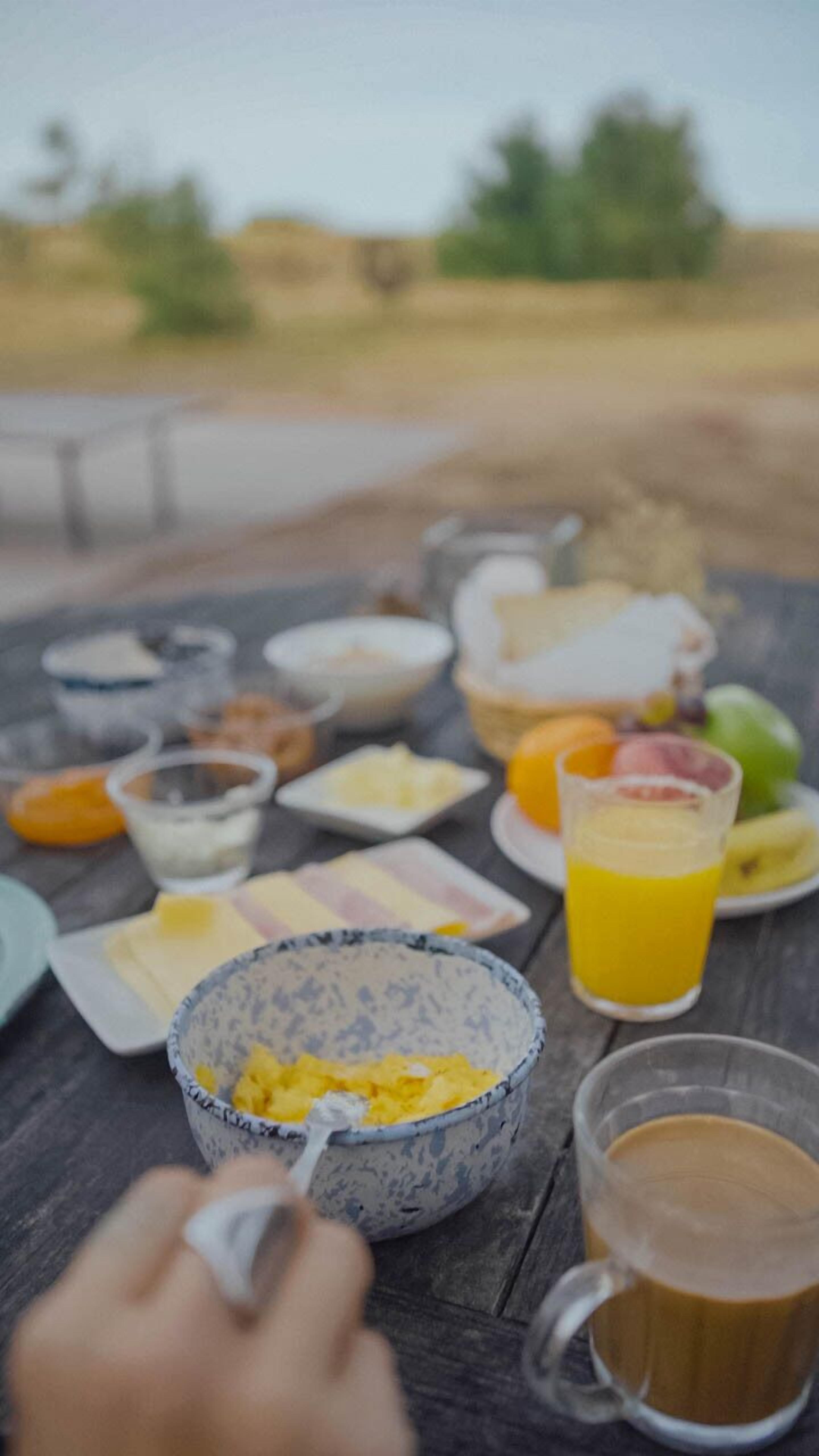 A breakfast table with various food items and drinks.
