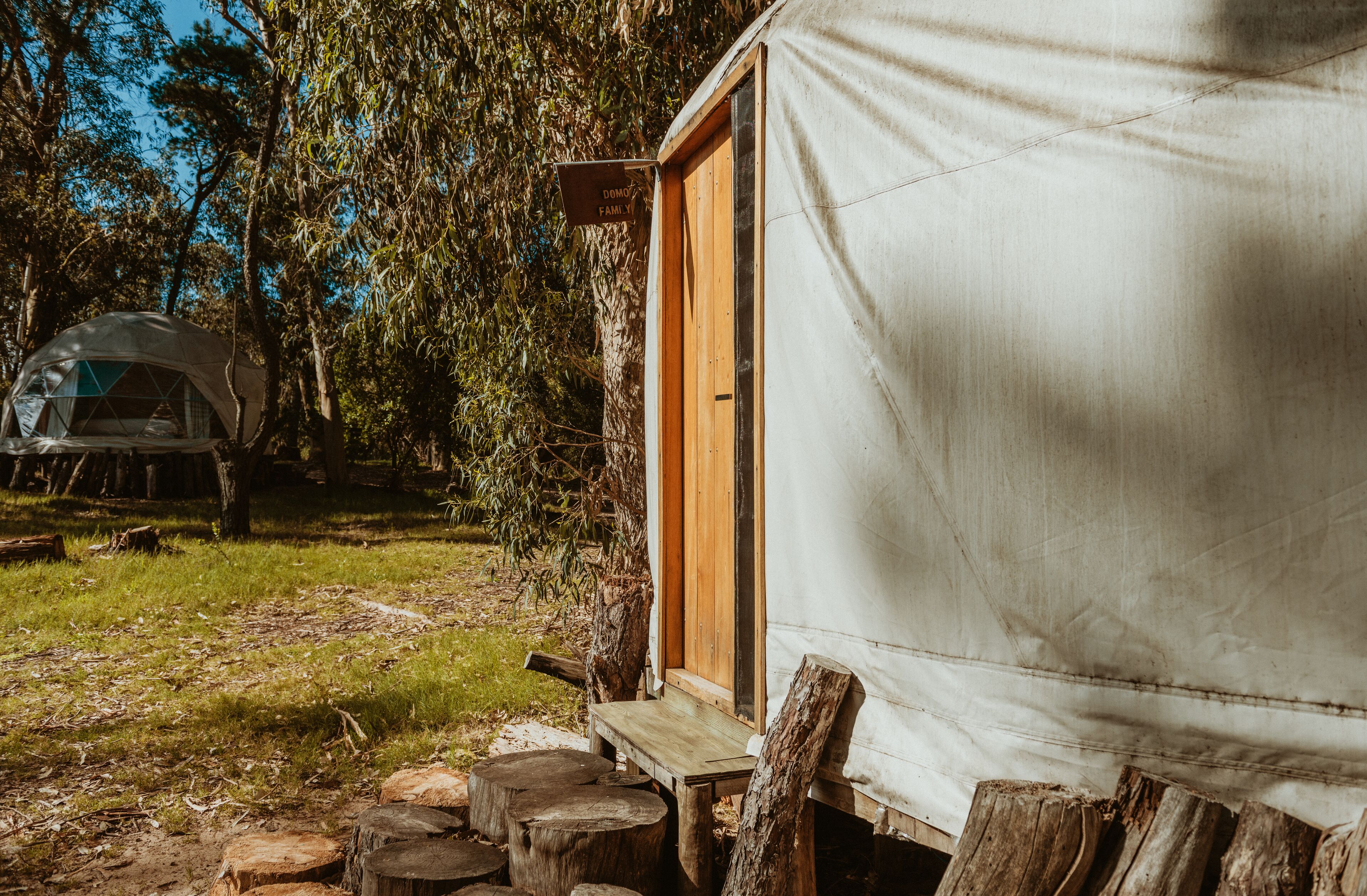A tented accommodation with a wooden door and a sign reading "DORM FAMILY".