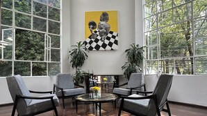 Una habitación amplia con ventanas grandes, piso a cuadros y muebles modernos.
