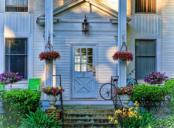 A house with a front porch, a door with a number, and hanging flower baskets. - Fountain ViewII~Charming historical building in the heart of downtown Wellsboro. (Wellsboro)