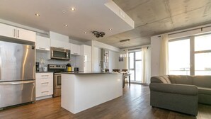 Une cuisine moderne avec des meubles blancs, des appareils en acier inoxydable et un îlot central.