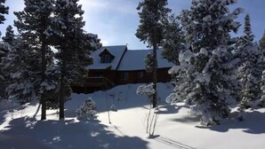 A snow-covered landscape with a house, surrounded by snow-laden trees. - Mtn Retreat: Hike ,Hot Tub, Explore CO, Ski, Relax (Golden)