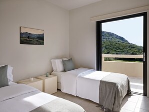 Una habitación de hotel moderna con dos camas, una mesita de noche, un cuadro y un balcón con vistas a la montaña.