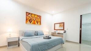 A modern bedroom with a bed, nightstands, a painting, and a mirror. - Deluxe Bungalow with Terrace, Pini Sentana Village (Nusa Penida)