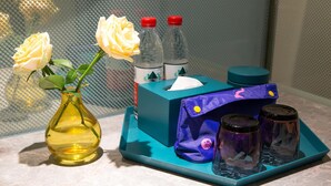 A bathroom vanity with a vase of white roses, a tissue box, and two bottles of hand sanitizer. - Manxin Hotel Changsha IFS (Changsha)