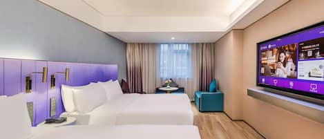 A hotel room with two beds, a TV mounted on the wall, a small table, and a chair.